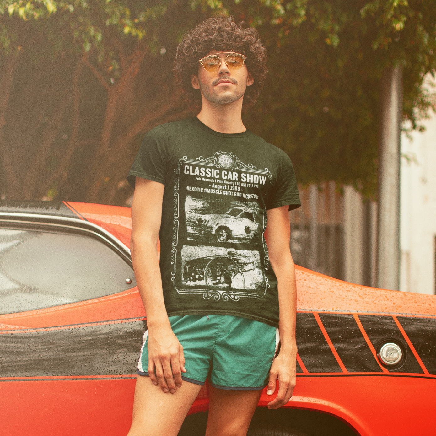 Cool guy looking all '80s in front of muscle car wearing a Numb Skull Designs tee.