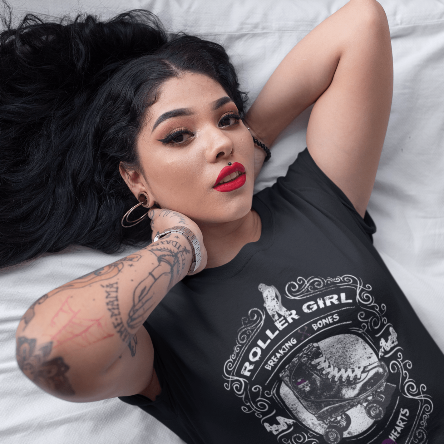 young woman with tattoos wearing roller girl tee